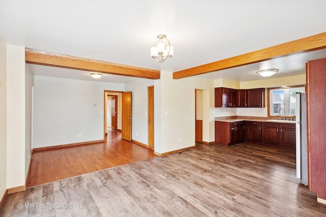 7241 N Mcvicker Ave, Chicago, IL 60646 - kitchen featuring wood finished floors, a chandelier, light countertops, beam ceiling, and open floor plan