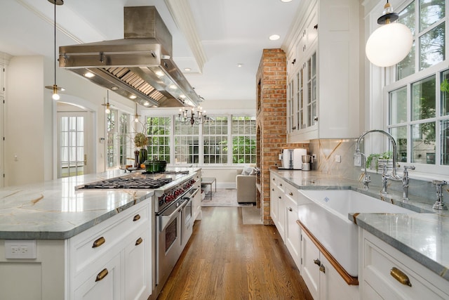 2131 W Schiller St, Chicago, IL 60622 - kitchen with range with two ovens, dark wood-style floors, island range hood, glass insert cabinets, and light stone counters