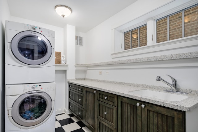 2131 W Schiller St, Chicago, IL 60622 - laundry area featuring stacked washer / dryer, tile patterned floors, and cabinet space