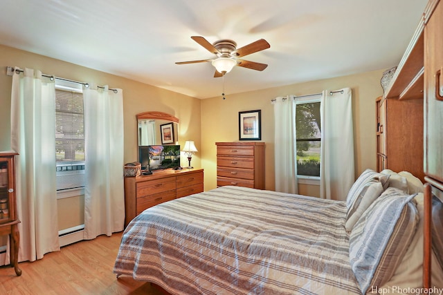 3914 N Richmond Rd, Johnsburg, IL 60051 - bedroom featuring multiple windows, light wood-style flooring, ceiling fan, and a baseboard radiator