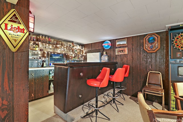 3914 N Richmond Rd, Johnsburg, IL 60051 - indoor dry bar with freestanding refrigerator, wood walls, and tile patterned floors
