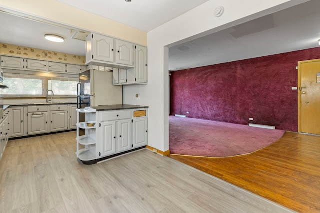 8716 S Merrill Ave, Chicago, IL 60617 - kitchen with an accent wall, wallpapered walls, light wood-type flooring, open shelves, and dark countertops