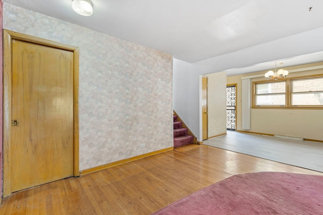 8716 S Merrill Ave, Chicago, IL 60617 - spare room with hardwood / wood-style flooring, a chandelier, stairway, and wallpapered walls