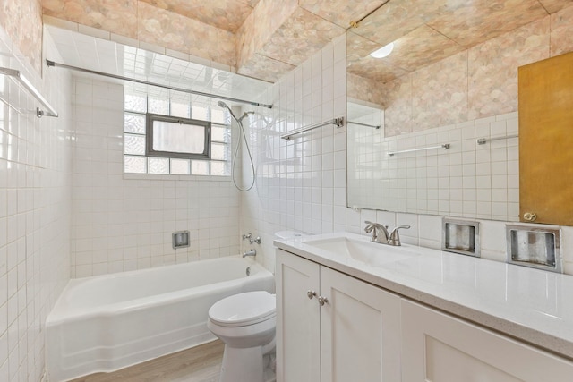 8716 S Merrill Ave, Chicago, IL 60617 - bathroom featuring tile walls, wood finished floors, washtub / shower combination, vanity, and tasteful backsplash