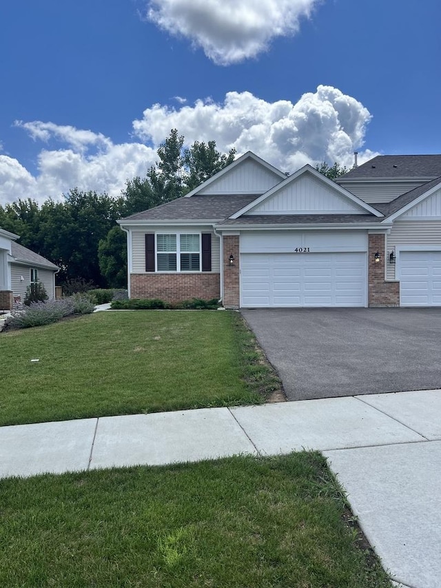 4021 Monica Ln Unit 1, Johnsburg, IL 60051 - ranch-style home featuring brick siding, driveway, a front yard, and an attached garage