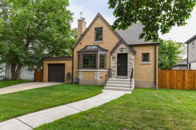 5309 Crain St, Skokie, IL 60077 - english style home with a chimney, driveway, an attached garage, stone siding, and brick siding
