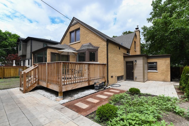 5309 Crain St, Skokie, IL 60077 - back of house featuring brick siding, a patio area, a wooden deck, a chimney, and roof with shingles