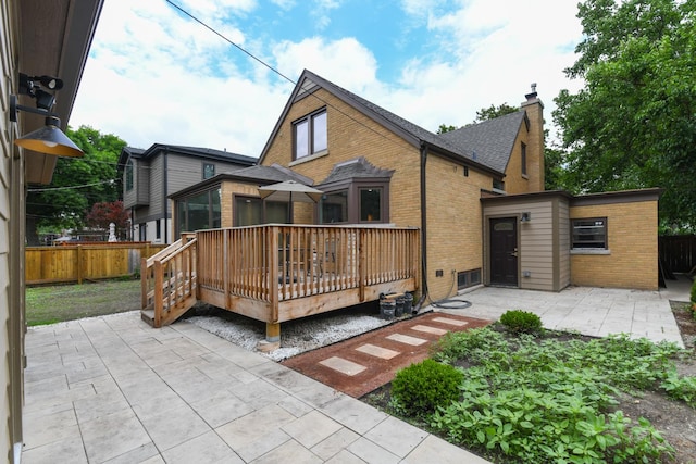 5309 Crain St, Skokie, IL 60077 - rear view of property featuring a patio, brick siding, a wooden deck, a chimney, and a shingled roof