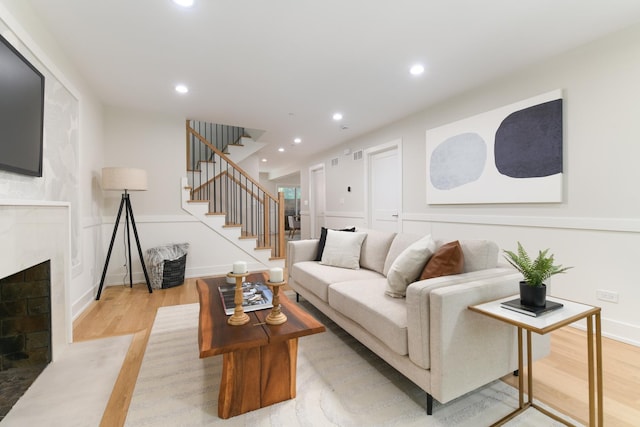 5309 Crain St, Skokie, IL 60077 - living area with light wood-style flooring, a fireplace with flush hearth, stairs, and recessed lighting