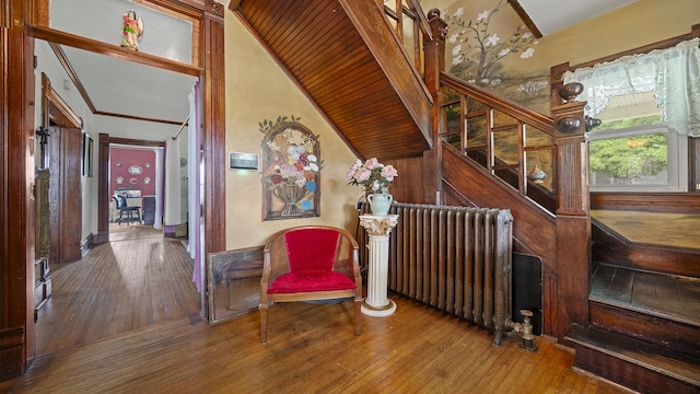 123 E 3rd St, Byron, IL 61010 - stairs with hardwood / wood-style flooring, radiator heating unit, and a towering ceiling