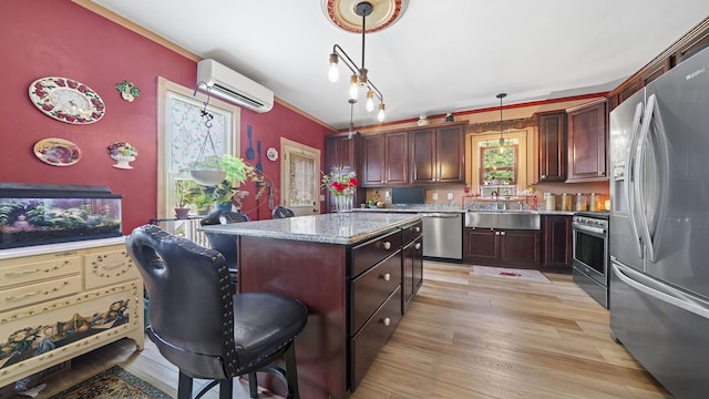 123 E 3rd St, Byron, IL 61010 - kitchen with stainless steel appliances, a wall mounted AC, a kitchen island, decorative light fixtures, and light wood-type flooring