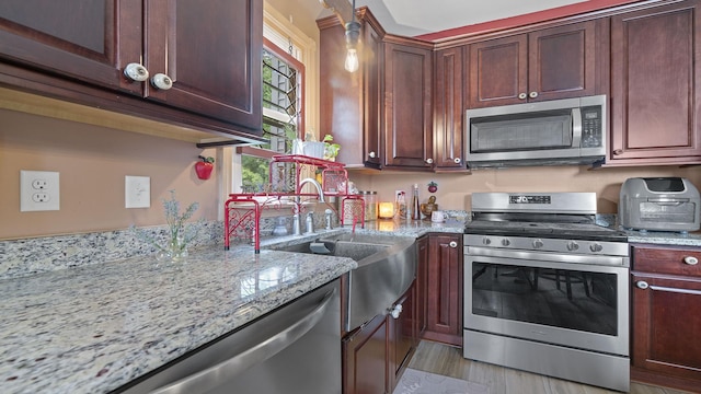 123 E 3rd St, Byron, IL 61010 - kitchen featuring appliances with stainless steel finishes, light stone countertops, and light wood finished floors