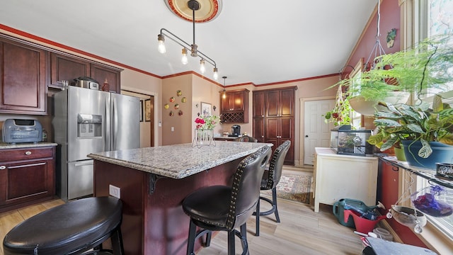 123 E 3rd St, Byron, IL 61010 - kitchen featuring stainless steel fridge with ice dispenser, light wood-style flooring, a kitchen island, light stone countertops, and a breakfast bar