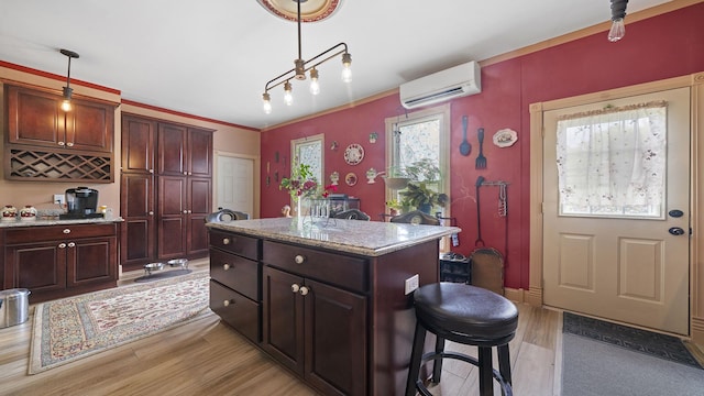 123 E 3rd St, Byron, IL 61010 - kitchen with light wood-style flooring, a wall mounted AC, pendant lighting, a center island, and a kitchen bar