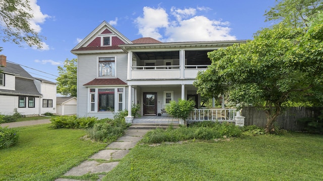 123 E 3rd St, Byron, IL 61010 - victorian home featuring covered porch, a front yard, a detached garage, and roof with shingles