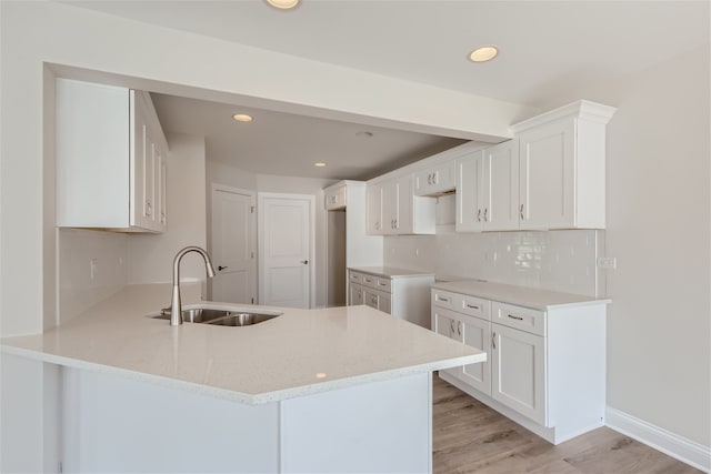 21210 Shannon Dr, Matteson, IL 60443 - kitchen with a peninsula, light stone countertops, white cabinets, backsplash, and light wood-type flooring