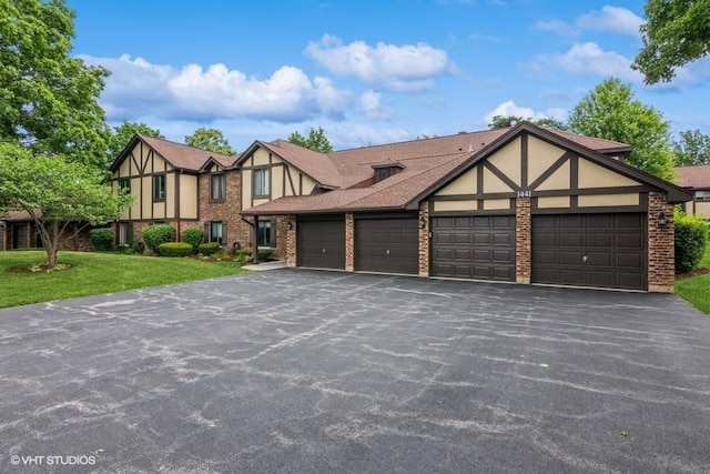 1441 Haverhill Dr Unit B, Wheaton, IL 60189 - tudor-style house featuring a garage, stucco siding, brick siding, a front lawn, and asphalt driveway