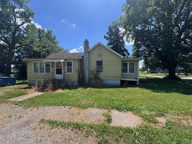 203 N Center St, Colfax, IL 61728 - view of front of home featuring a front yard and a chimney