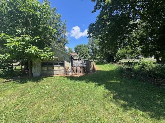 203 N Center St, Colfax, IL 61728 - view of green lawn featuring an outbuilding and a garage