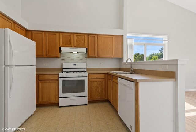 2715 Hoffman St, Plano, IL 60545 - kitchen with white appliances, under cabinet range hood, light countertops, brown cabinetry, and a high ceiling