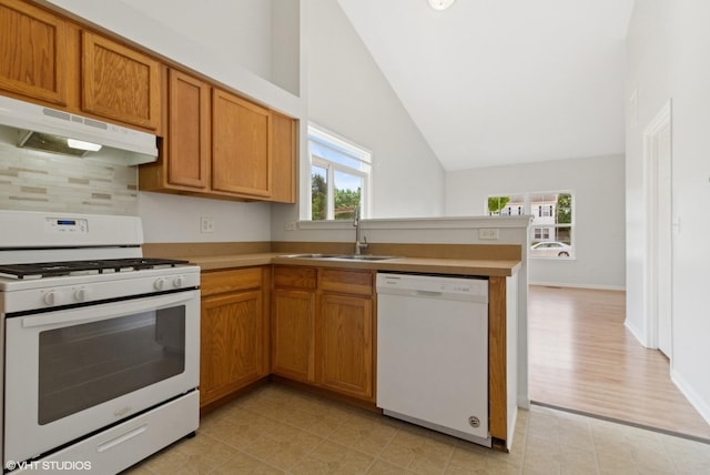 2715 Hoffman St, Plano, IL 60545 - kitchen with white appliances, under cabinet range hood, healthy amount of natural light, vaulted ceiling, and backsplash