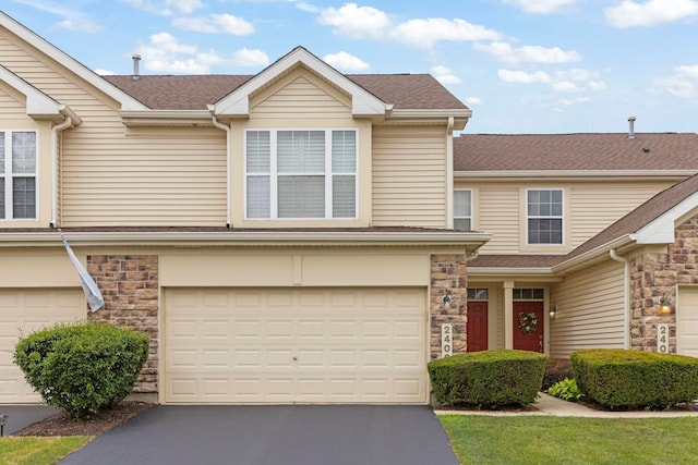 2406 Georgetown Cir, Aurora, IL 60503 - traditional-style house featuring an attached garage, driveway, stone siding, and a shingled roof