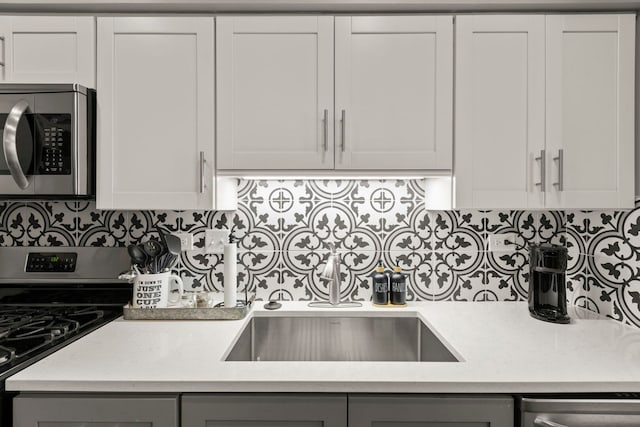 2406 Georgetown Cir, Aurora, IL 60503 - kitchen featuring stainless steel appliances, gray cabinets, light countertops, backsplash, and white cabinetry