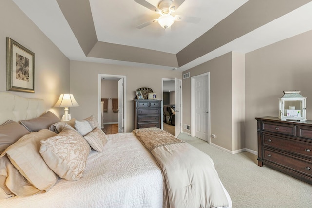 2406 Georgetown Cir, Aurora, IL 60503 - bedroom featuring a tray ceiling, light carpet, ensuite bathroom, a ceiling fan, and a walk in closet