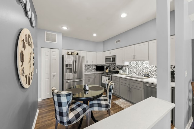 2406 Georgetown Cir, Aurora, IL 60503 - kitchen featuring appliances with stainless steel finishes, backsplash, gray cabinetry, dark wood-type flooring, and recessed lighting