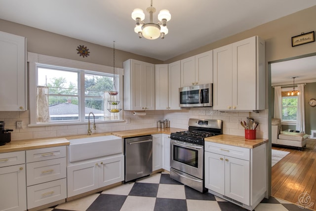 275 N Main St, Crystal Lake, IL 60014 - kitchen featuring appliances with stainless steel finishes, butcher block countertops, a chandelier, tasteful backsplash, and white cabinetry