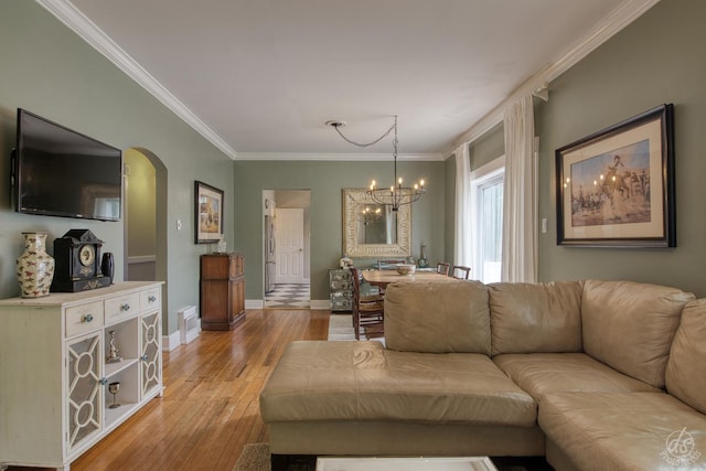 275 N Main St, Crystal Lake, IL 60014 - living room with ornamental molding, a chandelier, arched walkways, and light wood-style flooring
