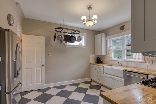 275 N Main St, Crystal Lake, IL 60014 - kitchen featuring wood counters, stainless steel appliances, dark flooring, a chandelier, and tasteful backsplash