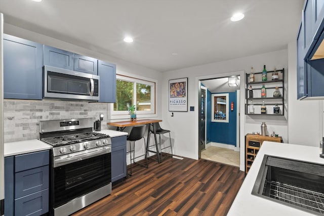 2620 Vermont St, Blue Island, IL 60406 - kitchen with stainless steel appliances, light countertops, backsplash, blue cabinets, and dark wood-type flooring