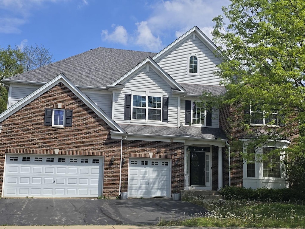 2221 Edgartown Ln, Hoffman Estates, IL 60192 - traditional-style house with driveway, a garage, and brick siding