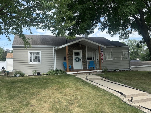 1805 Rock St, Peru, IL 61354 - view of front of house featuring a front yard, roof with shingles, covered porch, and stone siding