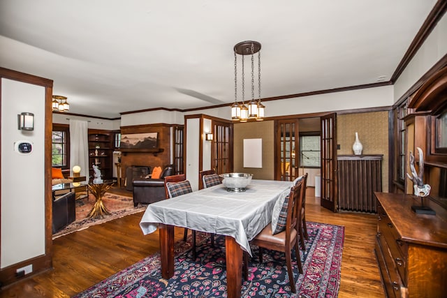 519 N Elmwood Ave, Oak Park, IL 60302 - dining area featuring dark wood-type flooring, ornamental molding, and a fireplace