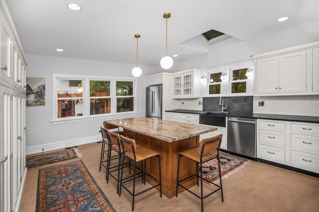 519 N Elmwood Ave, Oak Park, IL 60302 - kitchen with appliances with stainless steel finishes, a breakfast bar area, decorative backsplash, a kitchen island, and recessed lighting
