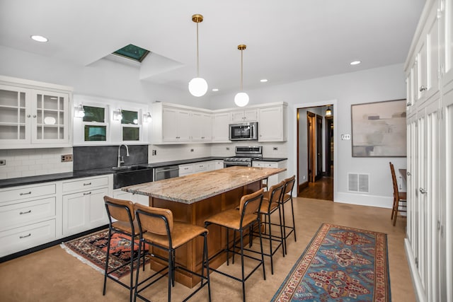 519 N Elmwood Ave, Oak Park, IL 60302 - kitchen with stainless steel appliances, a kitchen breakfast bar, a kitchen island, decorative backsplash, and recessed lighting