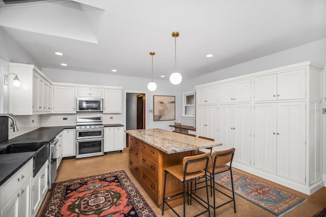 519 N Elmwood Ave, Oak Park, IL 60302 - kitchen featuring appliances with stainless steel finishes, white cabinets, recessed lighting, tasteful backsplash, and a breakfast bar