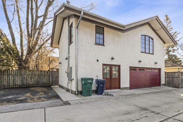 519 N Elmwood Ave, Oak Park, IL 60302 - back of property featuring an attached garage, driveway, stucco siding, and french doors
