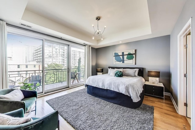 1600 S Wabash Ave Unit 4E, Chicago, IL 60616 - bedroom featuring a tray ceiling, access to outside, light wood-style flooring, and a chandelier