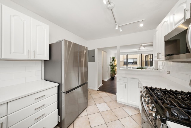 7409 N Seeley Ave Unit 2B, Chicago, IL 60645 - kitchen featuring stainless steel appliances, electric panel, track lighting, and decorative backsplash