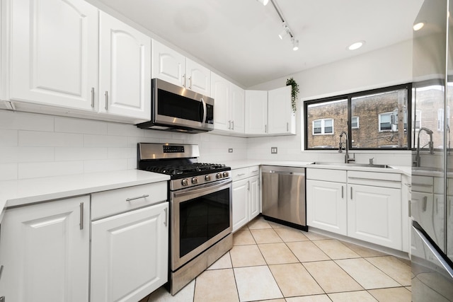 7409 N Seeley Ave Unit 2B, Chicago, IL 60645 - kitchen with appliances with stainless steel finishes, tasteful backsplash, white cabinets, and track lighting