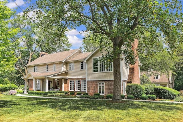 15606 W Sweedler Rd, Manhattan, IL 60442 - view of front facade featuring a chimney, brick siding, a front yard, and covered porch