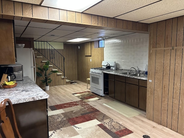 9362 Clancy Dr, Des Plaines, IL 60016 - kitchen with white appliances, light wood-style flooring, dark brown cabinets, light countertops, and a paneled ceiling
