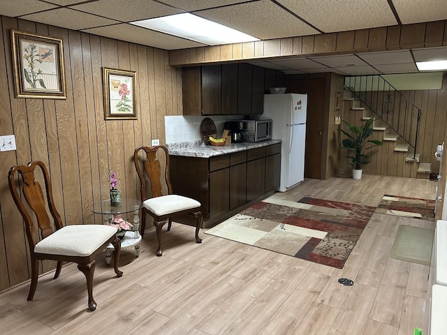 9362 Clancy Dr, Des Plaines, IL 60016 - kitchen featuring stainless steel microwave, a paneled ceiling, freestanding refrigerator, light wood-style floors, and light countertops