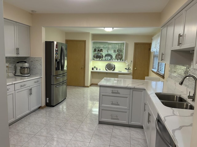 9362 Clancy Dr, Des Plaines, IL 60016 - kitchen featuring stainless steel appliances, gray cabinets, a peninsula, tasteful backsplash, and light stone countertops