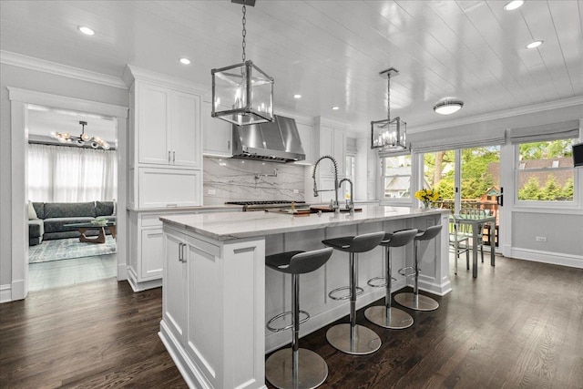 330 Abbotsford Rd, Kenilworth, IL 60043 - kitchen featuring a chandelier, exhaust hood, a kitchen island with sink, white cabinetry, and recessed lighting