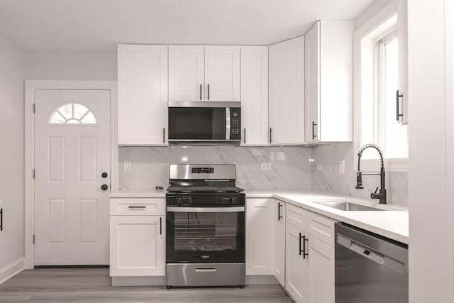 10940 S Trumbull Ave, Chicago, IL 60655 - kitchen with appliances with stainless steel finishes, light wood-style floors, decorative backsplash, and white cabinetry