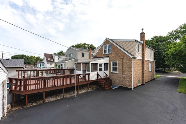 10940 S Trumbull Ave, Chicago, IL 60655 - back of house with a sunroom, a chimney, brick siding, and a wooden deck